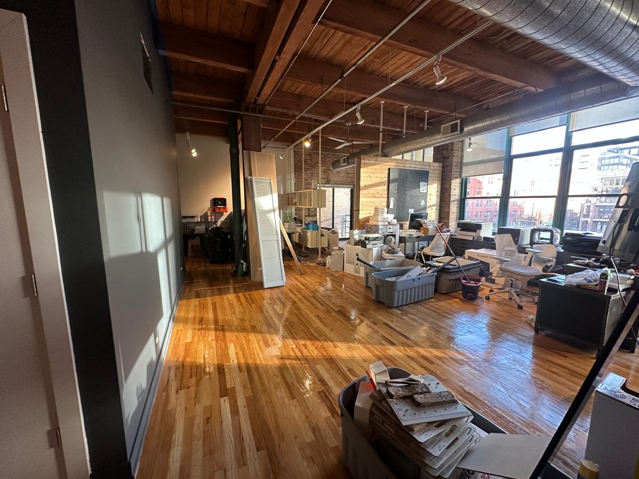 Loft industrial con piso de madera y vigas aparentes