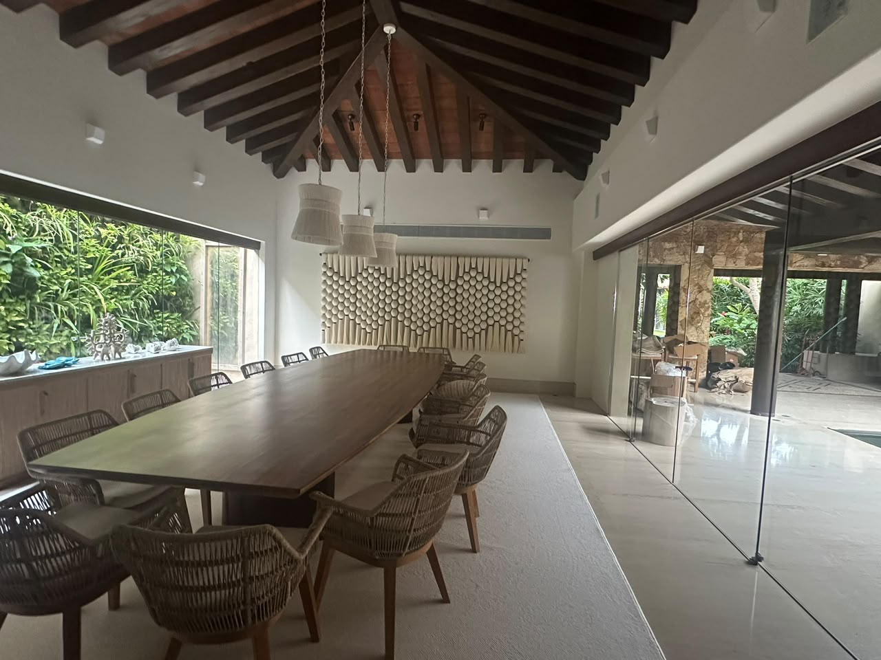Comedor con techo de vigas de madera y canceles de cristal